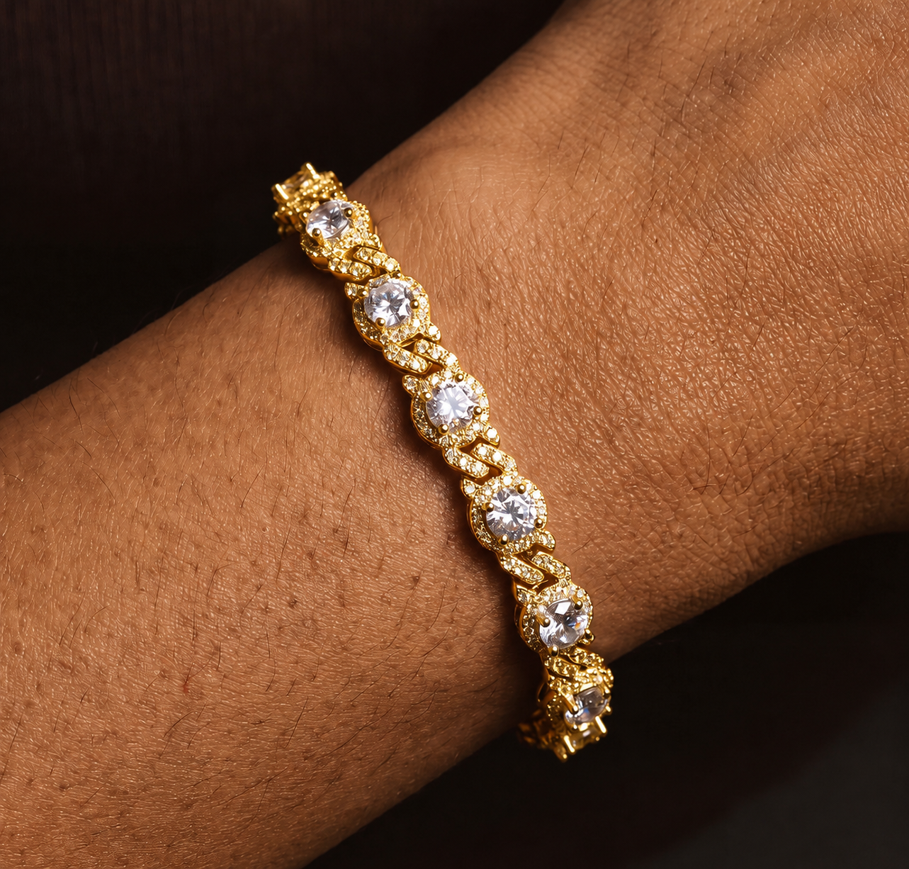 Gold-tone halo station Cuban link bracelet worn on a wrist